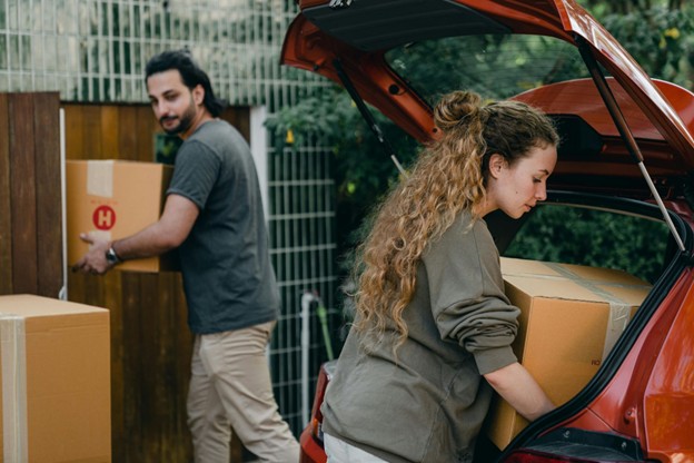 A couple loading boxes into their car